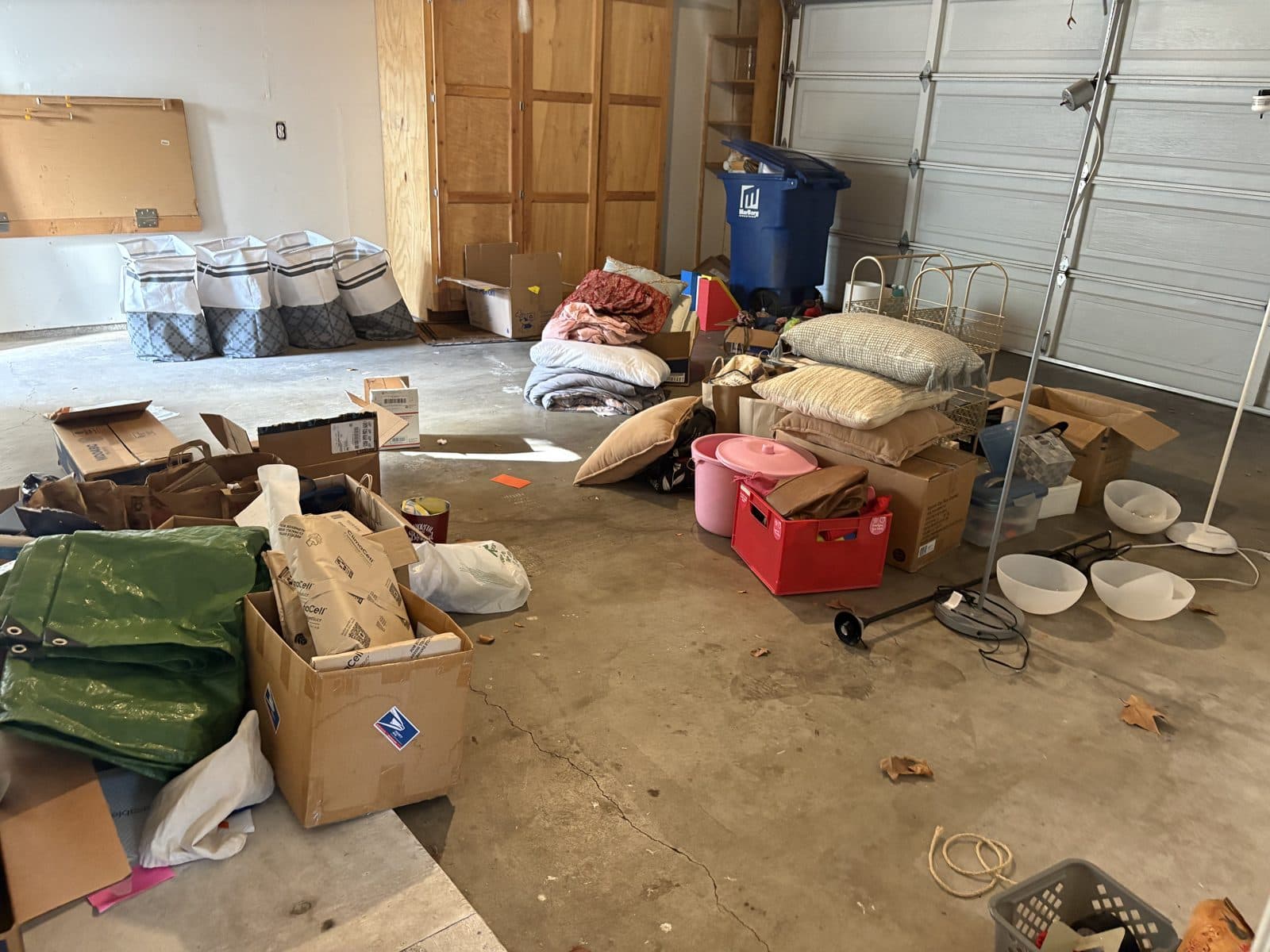 Garage packed with boxes, bins, and clutter before cleanout