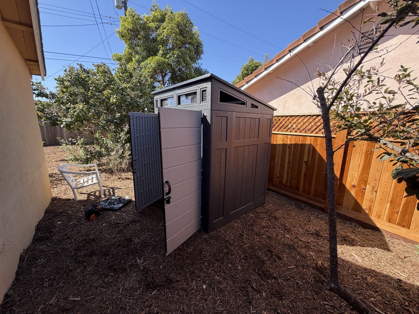 Assembled shed in a backyard with doors open